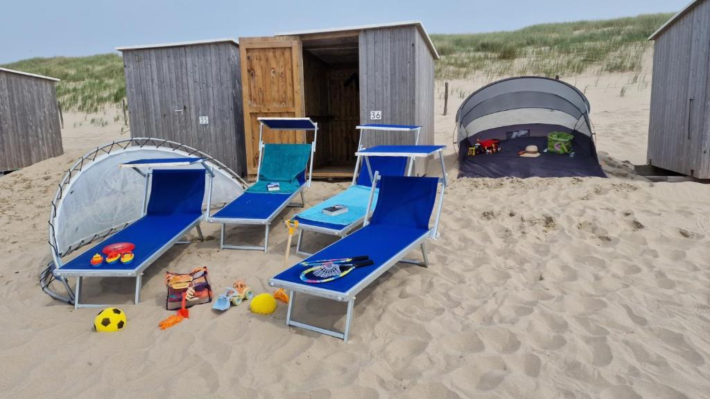 un gruppo di sedie e una tenda nella sabbia di Ferienhaus Weitblick a Sint Maarten
