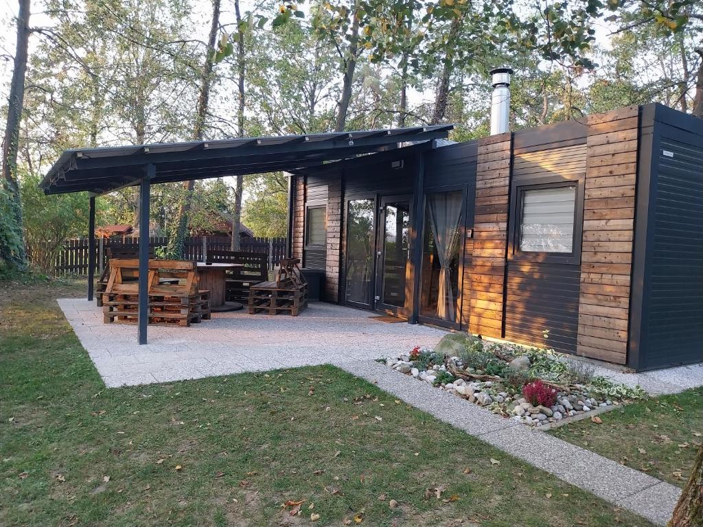 Cabaña pequeña con techo negro y patio en Metkina Hiška 