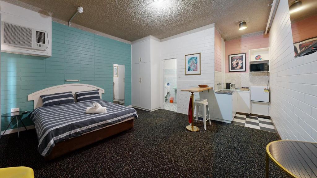 West End Motel في أديلايد: غرفة نوم فيها سرير ومغسلة