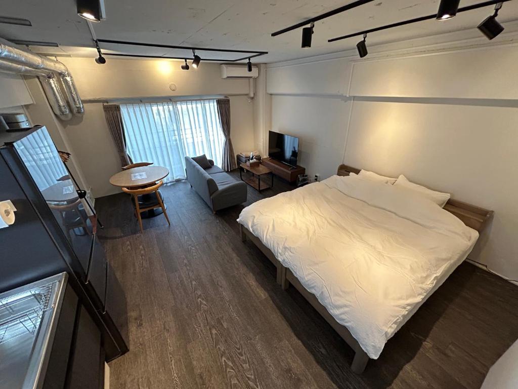 NIYS apartments 37 type في طوكيو: غرفة نوم بسرير وكرسي وطاولة