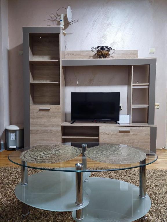 a living room with a tv and a glass table at Apartment Vuk in Podgorica