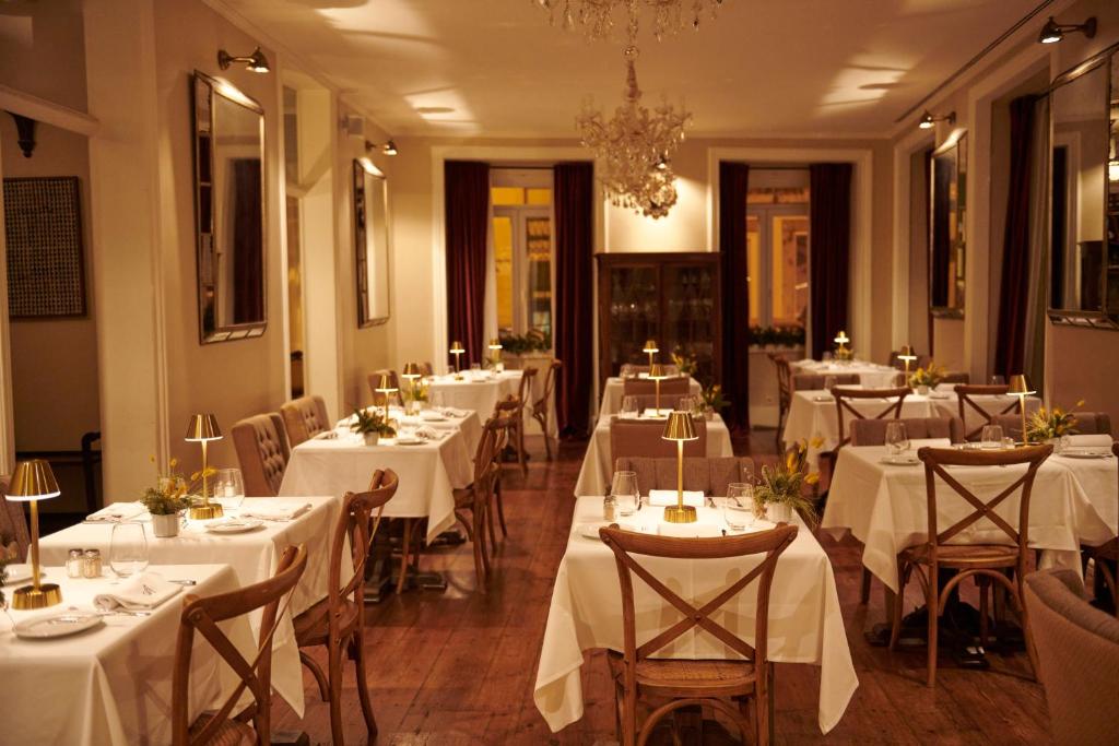 una sala da pranzo con tavoli con tovaglie bianche di Alegria A Lisbon Boutique Hotel a Lisbona