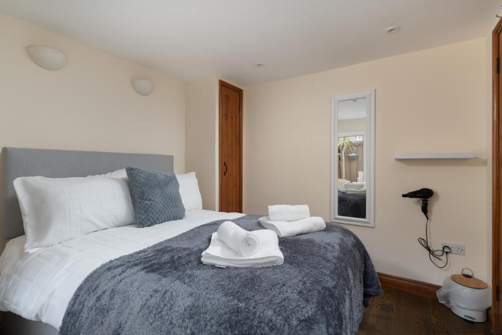 a bedroom with a bed with two towels on it at The Barn in St Just