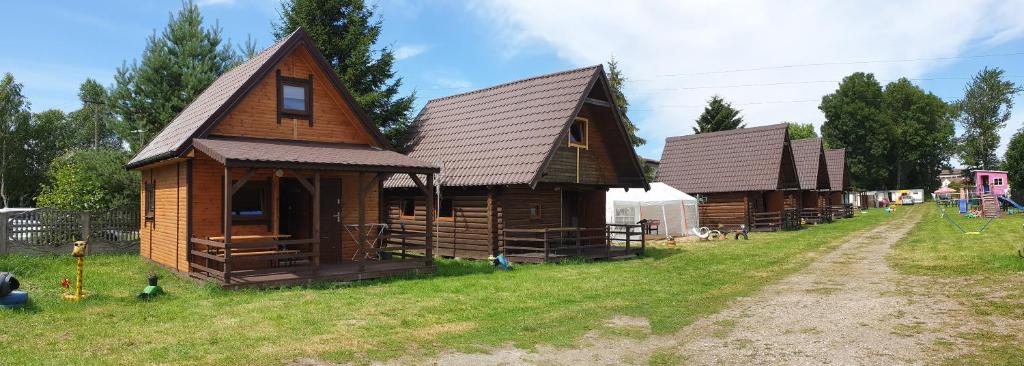a large wooden house on a grass field at Idylla in Chłopy