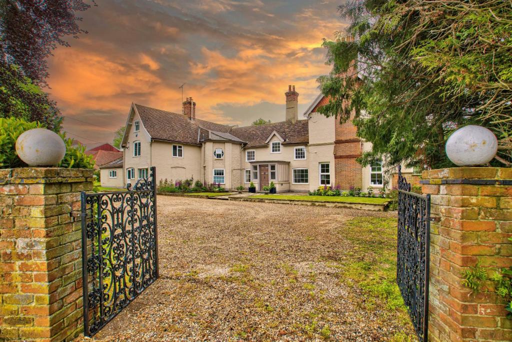 a house with a gate in front of it at Ashfield Place Farm by Group Retreats in Stowmarket