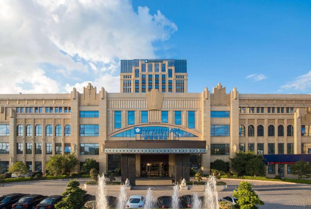 杭州的住宿－杭州英冠温德姆酒店，一座大型建筑,前面有一个喷泉