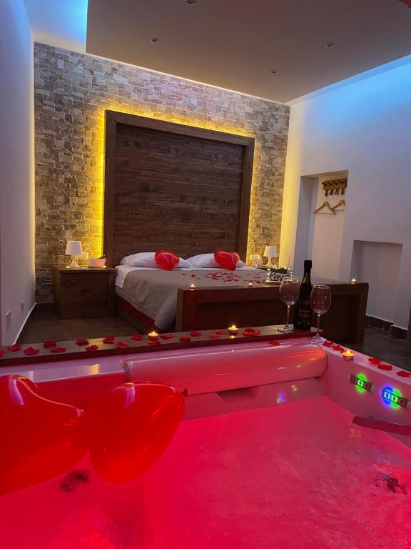 a bedroom with a bed and a tub with red lights at “La Casetta nel Borgo” in Cerveteri