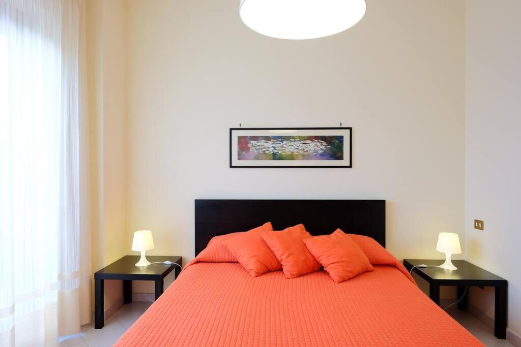 - une chambre avec un lit avec des draps orange et 2 lampes dans l'établissement Heart of Sorrento Apartment, à Sorrente