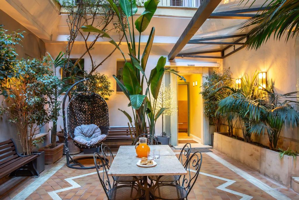 patio ze stołem, krzesłami i roślinami w obiekcie Hotel White w Rzymie
