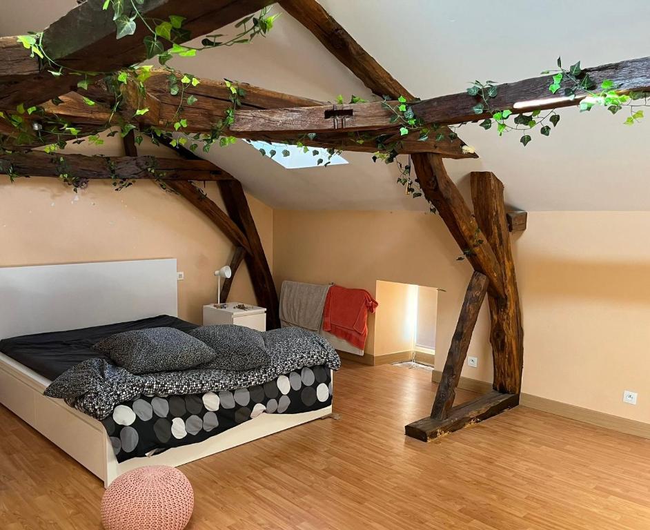um quarto com uma cama num sótão em La Bourgeoise em Neuvic