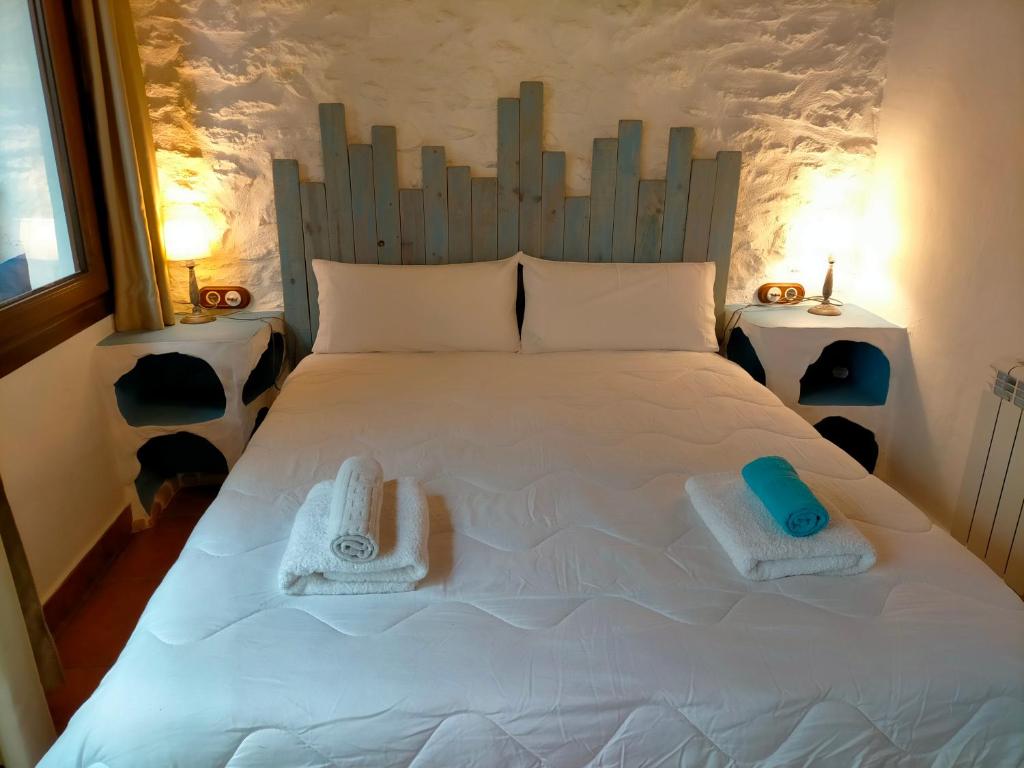 a large white bed with two towels on it at Albaga in Sant Jordi