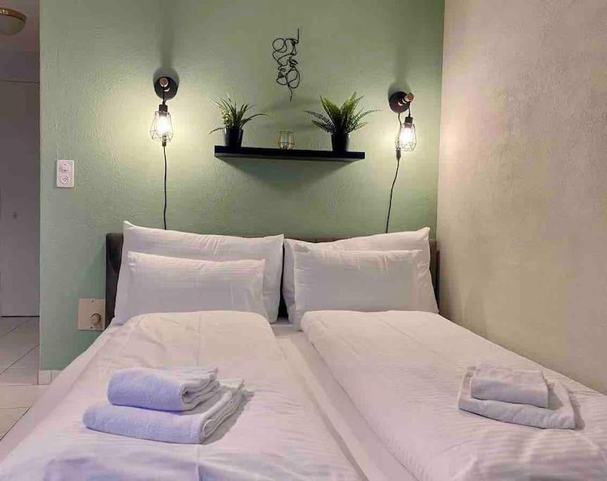 1 cama blanca grande con 2 toallas en HID AG: Lakeview Studio mit Parkplatz und Balkon, en Därligen