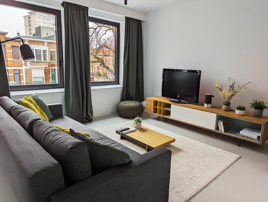 a living room with a couch and a flat screen tv at Spacious and cosy apartment near Berchem Station in Antwerp