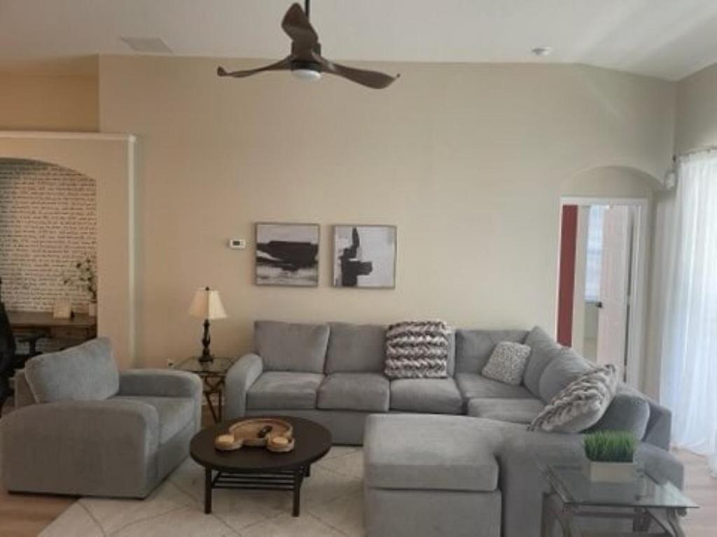 sala de estar con sofá y ventilador de techo en 4 BR Private Vacation Home, en Kissimmee
