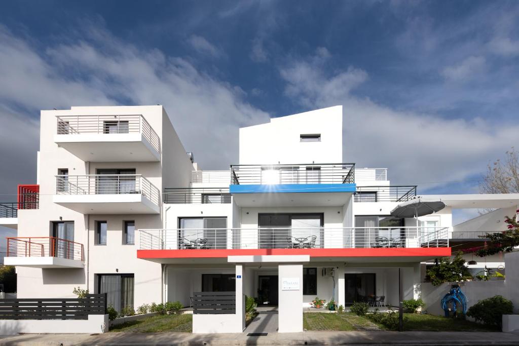 un edificio de apartamentos blanco con balcón rojo y azul en Pagani Green - Luxury Maisonette I2, en Kalamata