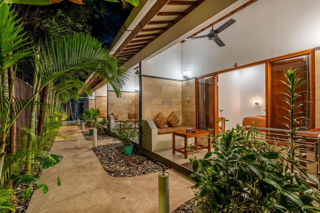 a living room with plants and a couch at Villa Doria formerly Rangga Homestay in Gili Islands