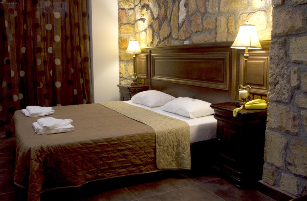 Iris Spa في لوترا إديبسو: غرفة فندق بسرير وجدار حجري