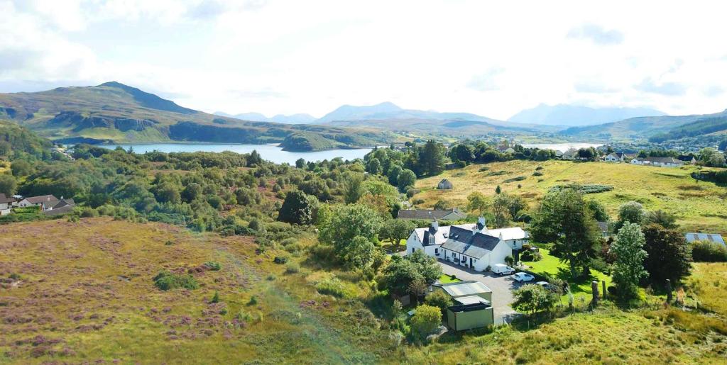 an aerial view of a house on a hill with a lake at Kiltaraglen House in Portree