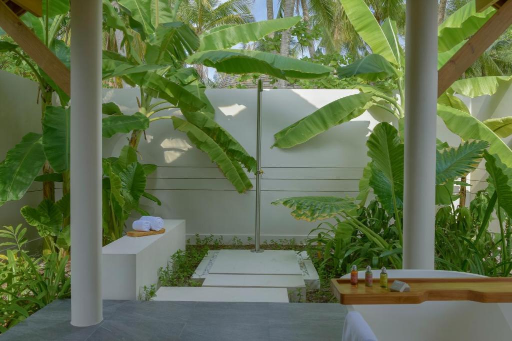 a courtyard with plants and stairs in a house at Emerald Faarufushi Resort & Spa - Deluxe All Inclusive in Raa Atoll