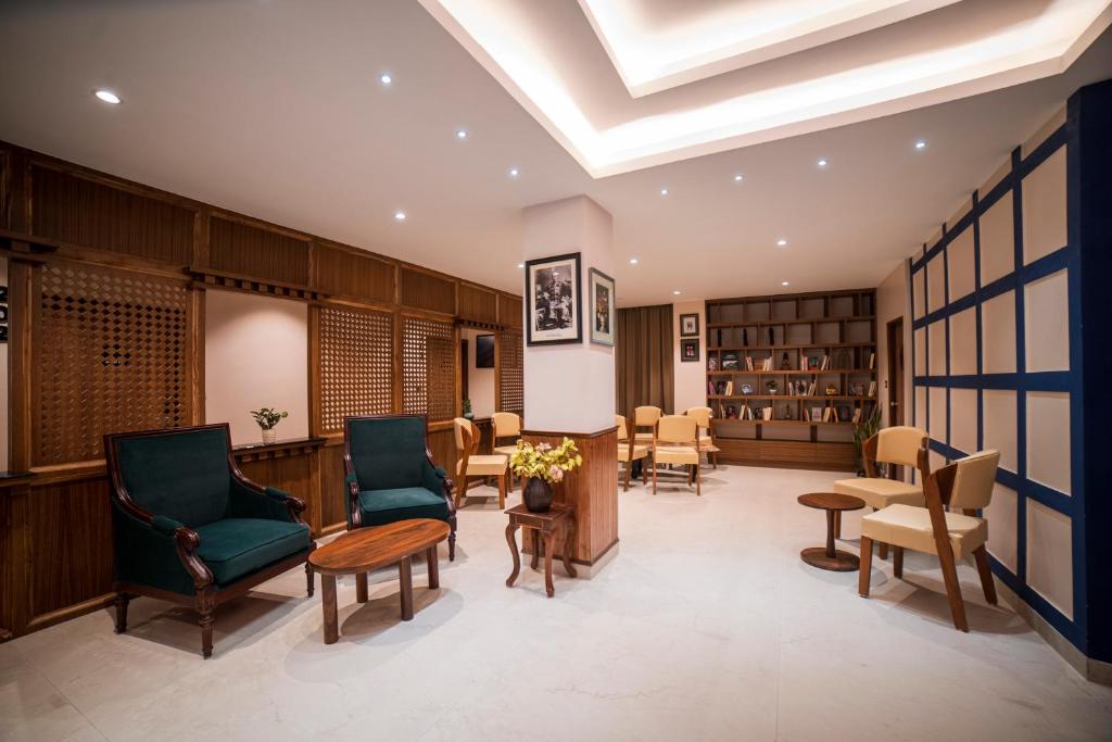 biblioteca con sillas, mesa y libros en Zip By Spree Hotels Gangtok en Gangtok