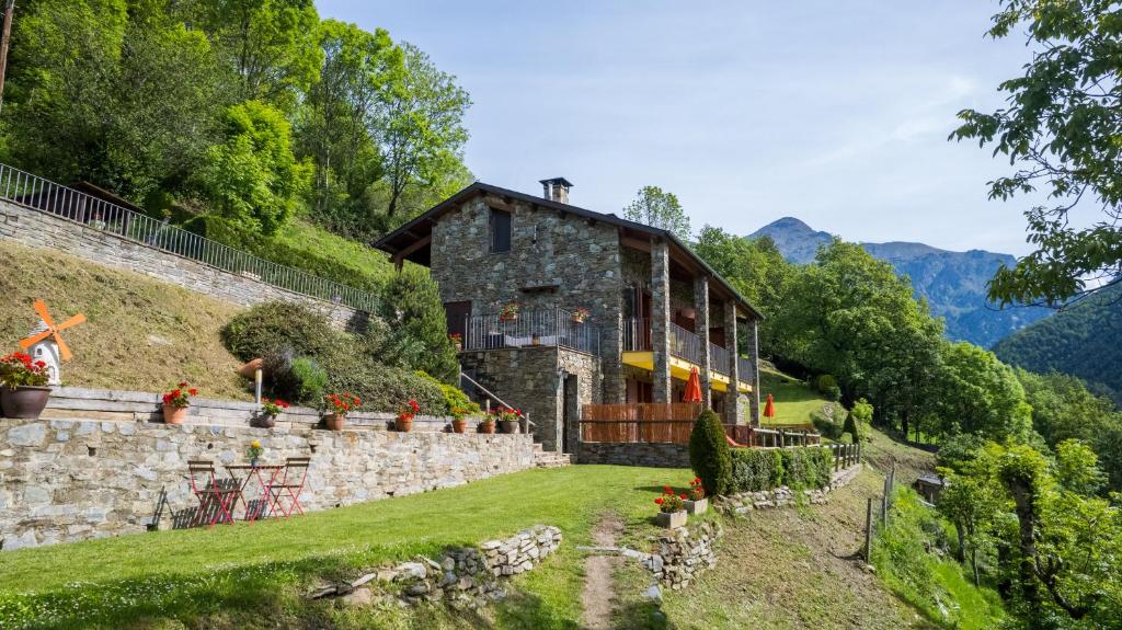 a building on a hill with a stone wall at Apartaments Fontalba in Queralbs