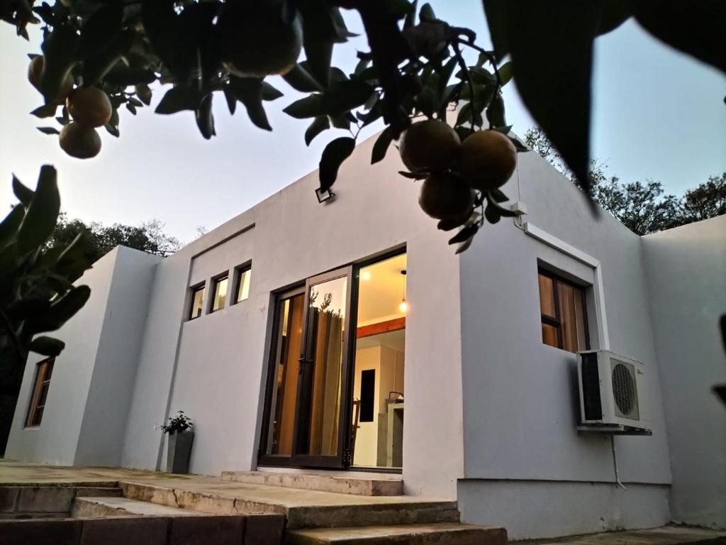 Una casa blanca con una puerta en el costado. en Witrivier Farmstay Self-Catering, en Cambria