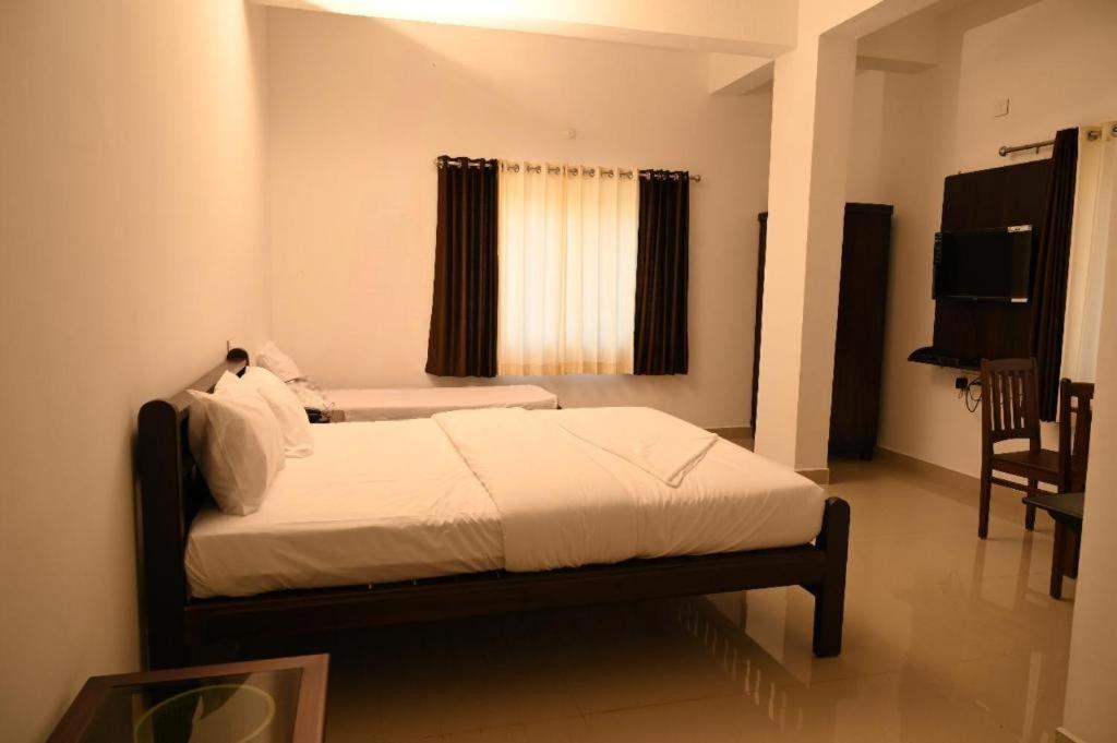 a bedroom with a bed in a room with a window at Hotel Mother Palace - Blue Rays in Baindūru