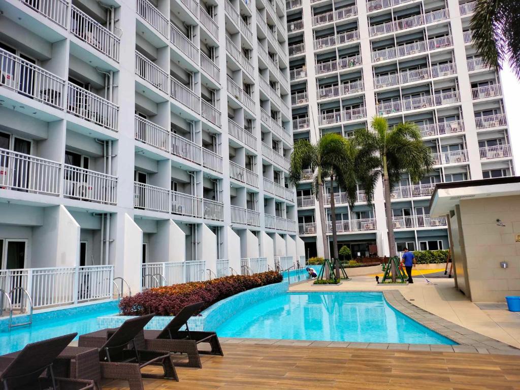 a swimming pool in front of a large apartment building at Smdc Breeze Residence in Manila