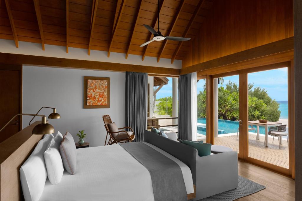 a bedroom with a bed and a view of the ocean at Emerald Faarufushi Resort & Spa - Deluxe All Inclusive in Raa Atoll