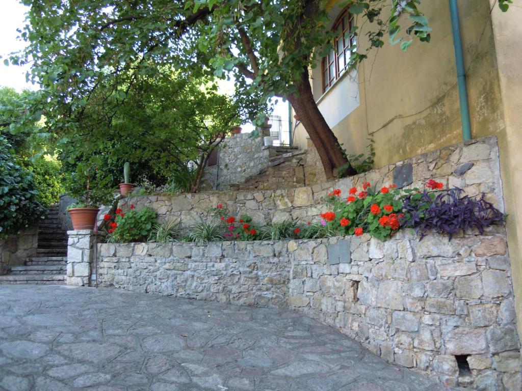a stone retaining wall with flowers in front of a building at Casa Elena in Lerici