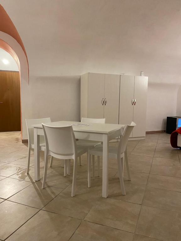 a dining room with a white table and chairs at Napoli Apartment in Naples