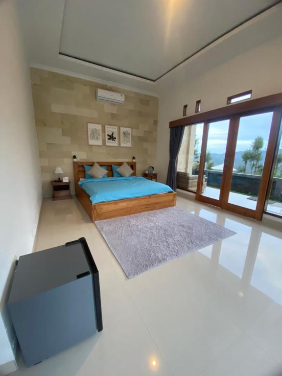 a bedroom with a bed and a flat screen tv at Batur Exotic Villa in Kubupenlokan