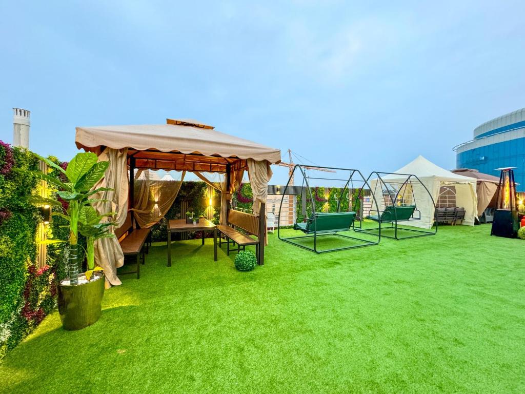a garden with a gazebo on the grass at Swat Hotel Apartments 4 in Al Khobar