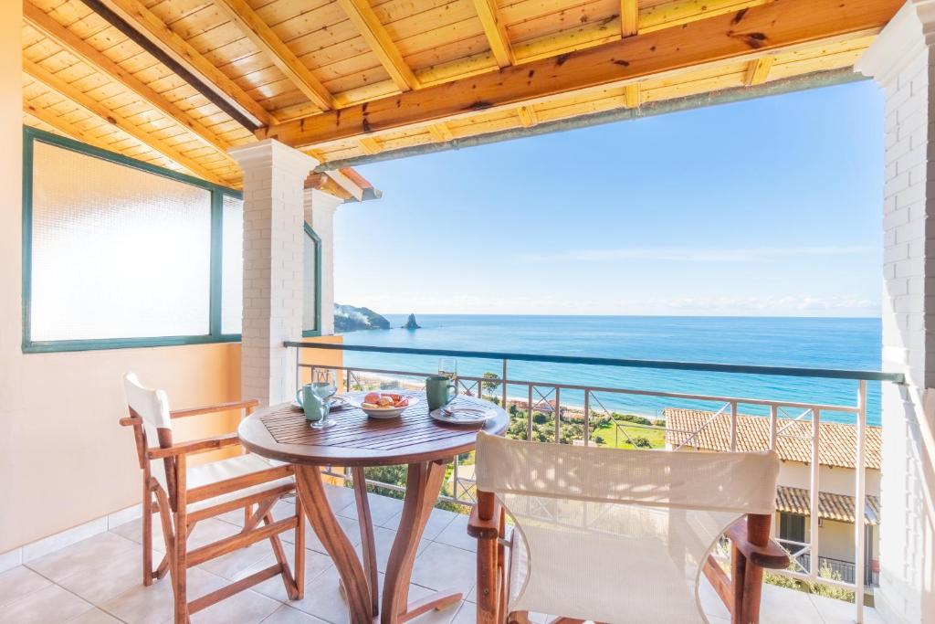 a table and chairs on a balcony with a view of the ocean at Lido Sofia Apartments in Agios Gordios