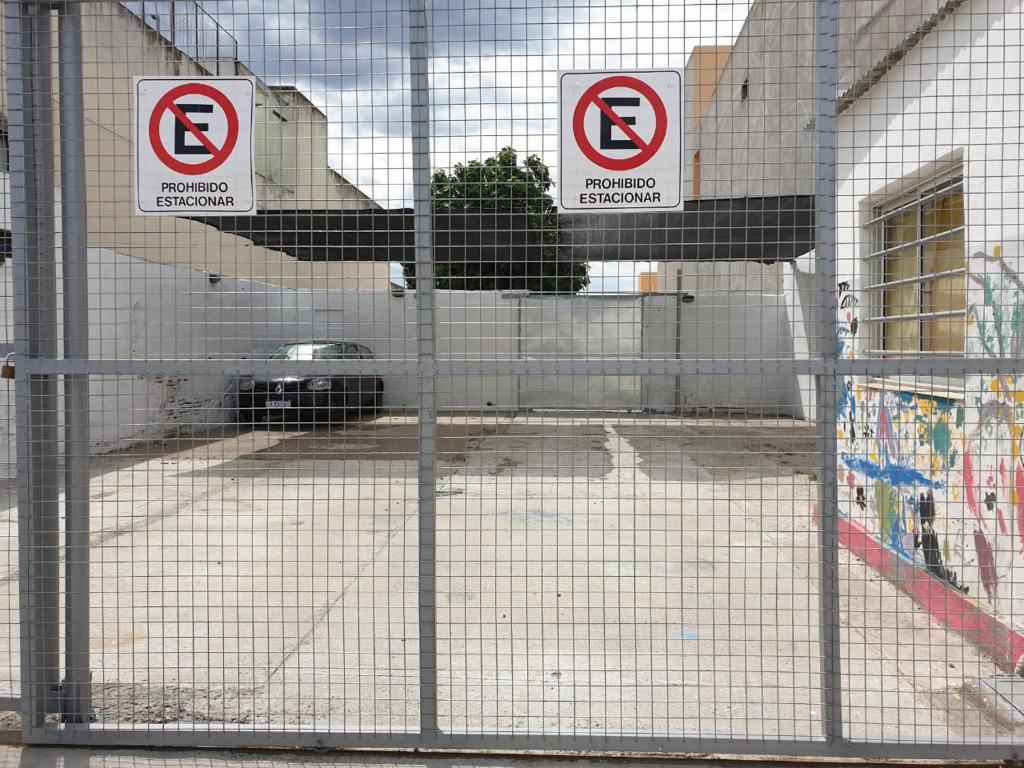 a fence with two no parking signs on it at SAN TAURO VIEDMA in Viedma