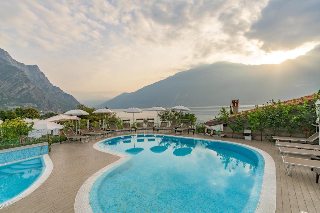 a large swimming pool with a view of the mountains at Garda Suite Hotel in Limone sul Garda