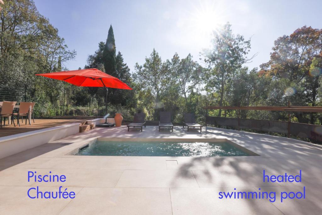 a patio with an umbrella and a swimming pool at Villa st Francois Piscine privée chauffée ,clim ,parking gratuit in Carcassonne