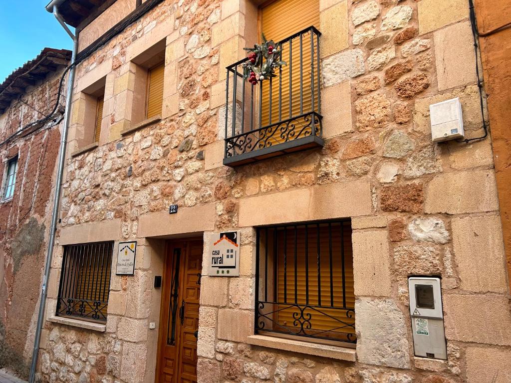 Edificio de piedra con balcón y ventana en Rincón de Ayllon, en Ayllón