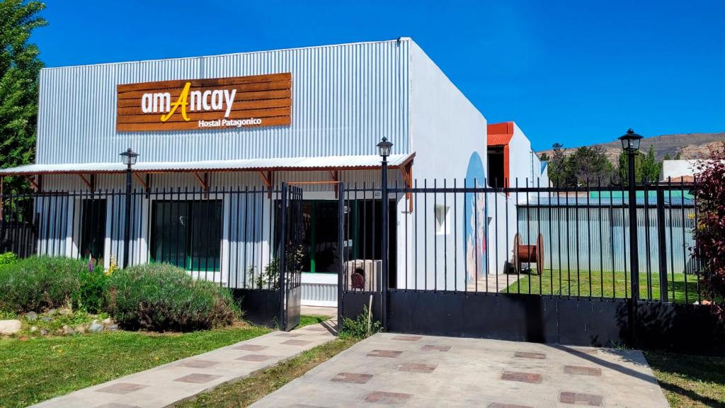 Amancay, hostal patagonico في إل كالافاتي: مبنى امامه سياج
