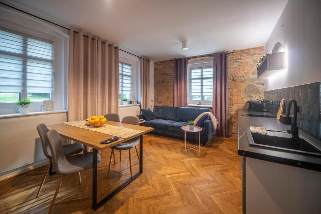 a kitchen and living room with a table and a couch at Apartamenty Śnieżna 12 Lądek- Zdrój in Lądek-Zdrój