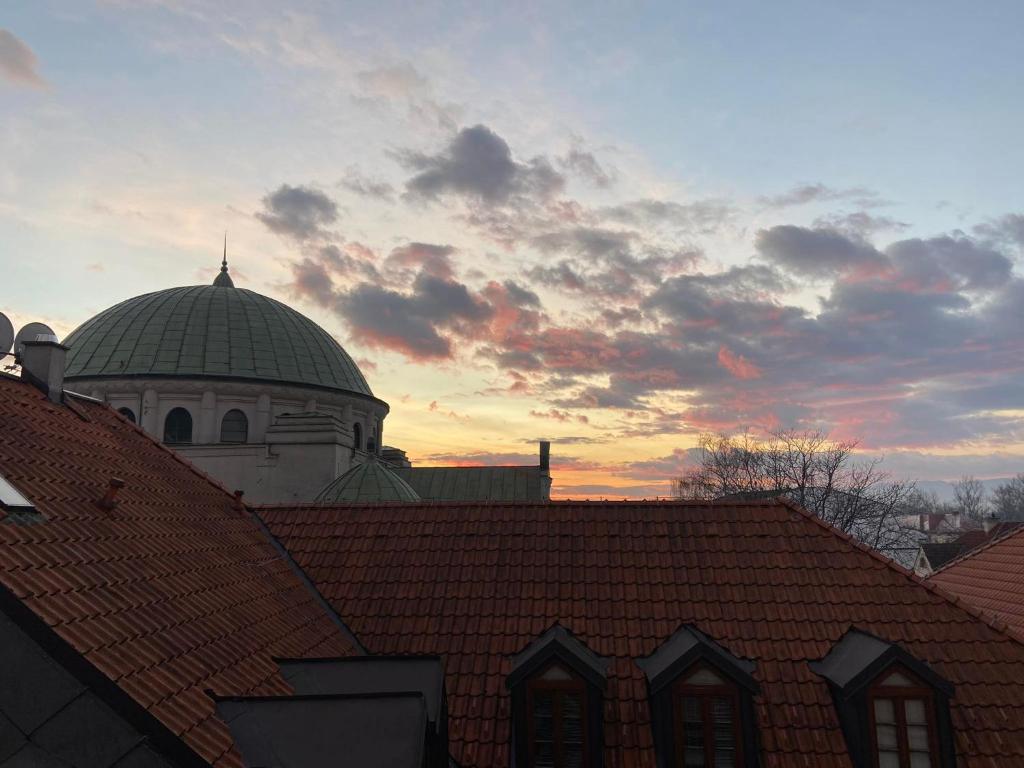 a building with a domed roof with a sunset in the background at LINDA apartment in Trenčín
