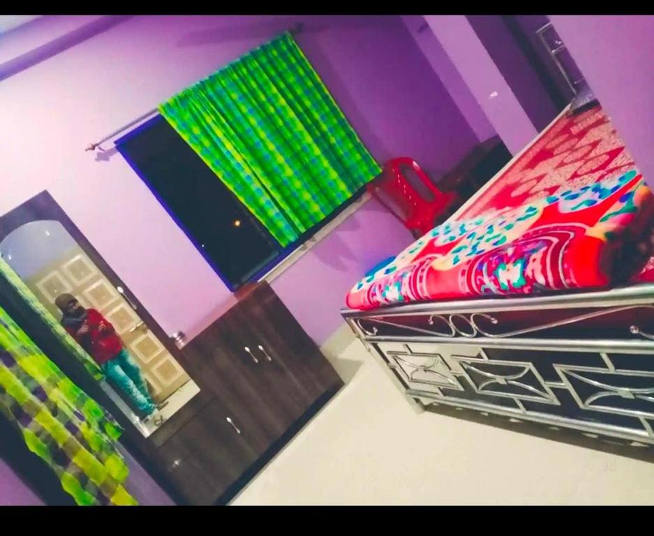 Una habitación con una cama con luces verdes. en Barsha guest house en Bolpur