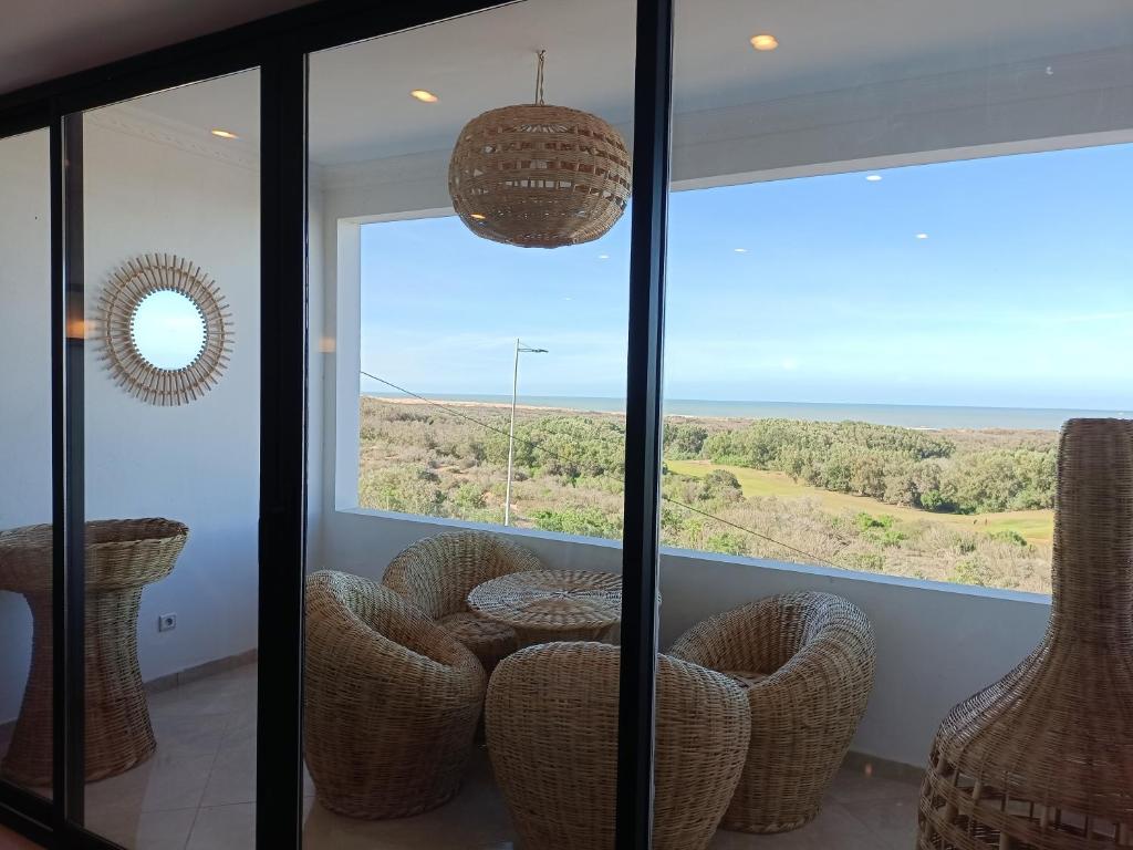 una camera con porta a vetri e vista sull'oceano di Appartement golf Mogador a Essaouira