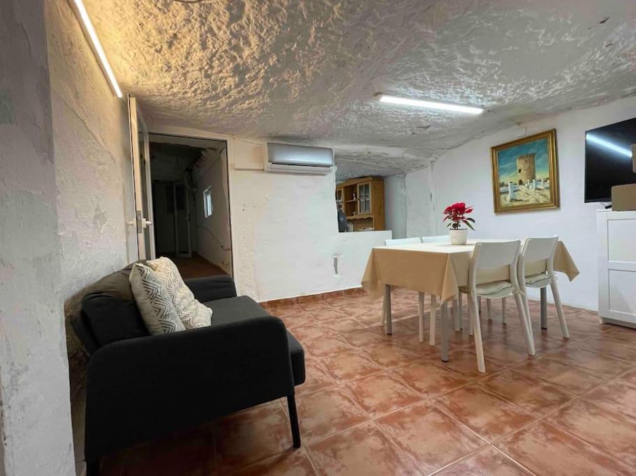 a living room with a table and a dining room at LA CUEVA de TONI EL SECO in Paterna