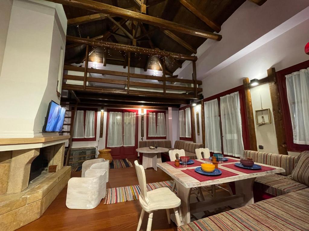 uma sala de estar com uma mesa e uma lareira em Traditional residence in Arachova center em Arachova