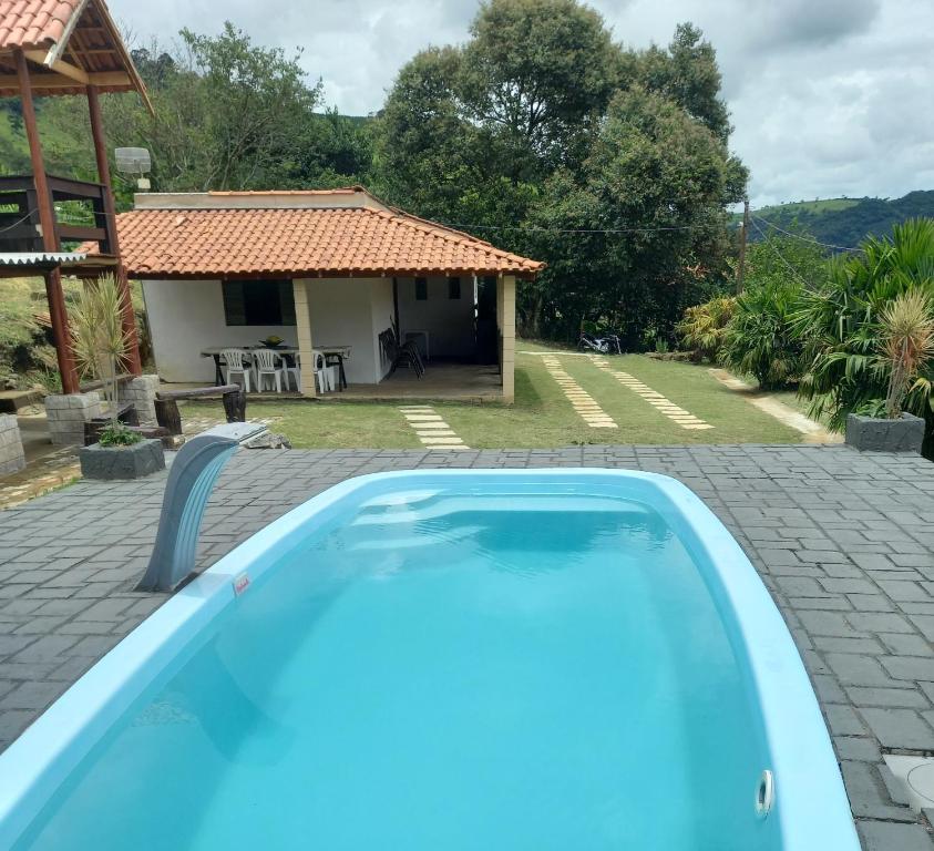 a swimming pool in front of a house at Chácara dos Ypes in Bueno Brandão