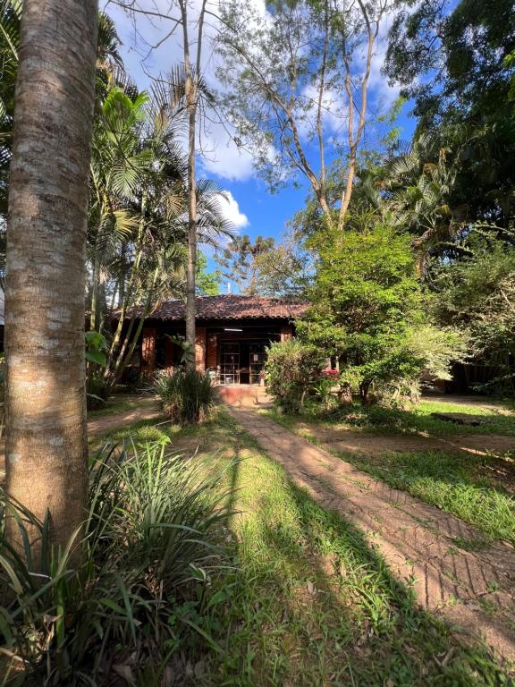 uma casa na selva com uma estrada de terra em frente em Hotel Pousada Cata Branca em Itabirito