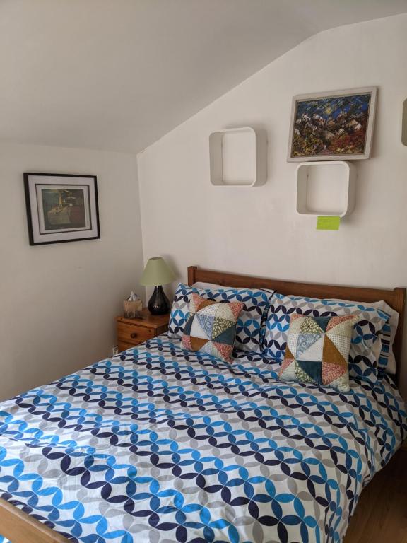 Schlafzimmer mit einem Bett mit einer blauen und weißen Bettdecke in der Unterkunft Central and peaceful room with your own bathroom in London