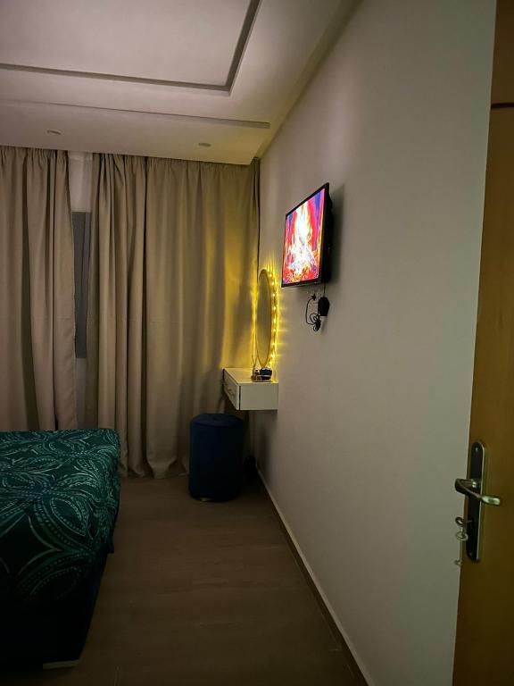 Zimmer mit einem Bett und einem TV an der Wand in der Unterkunft Charmante in Kenitra