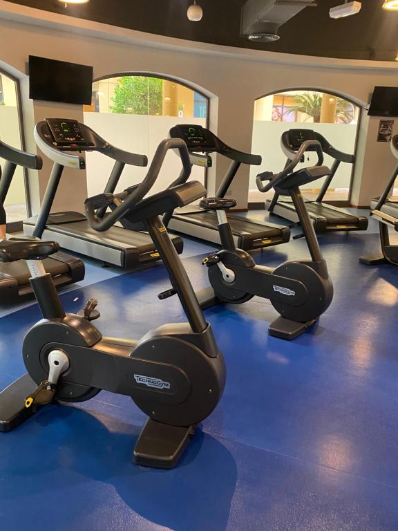 a gym with several tread machines on a blue floor at the971stay in Dubai